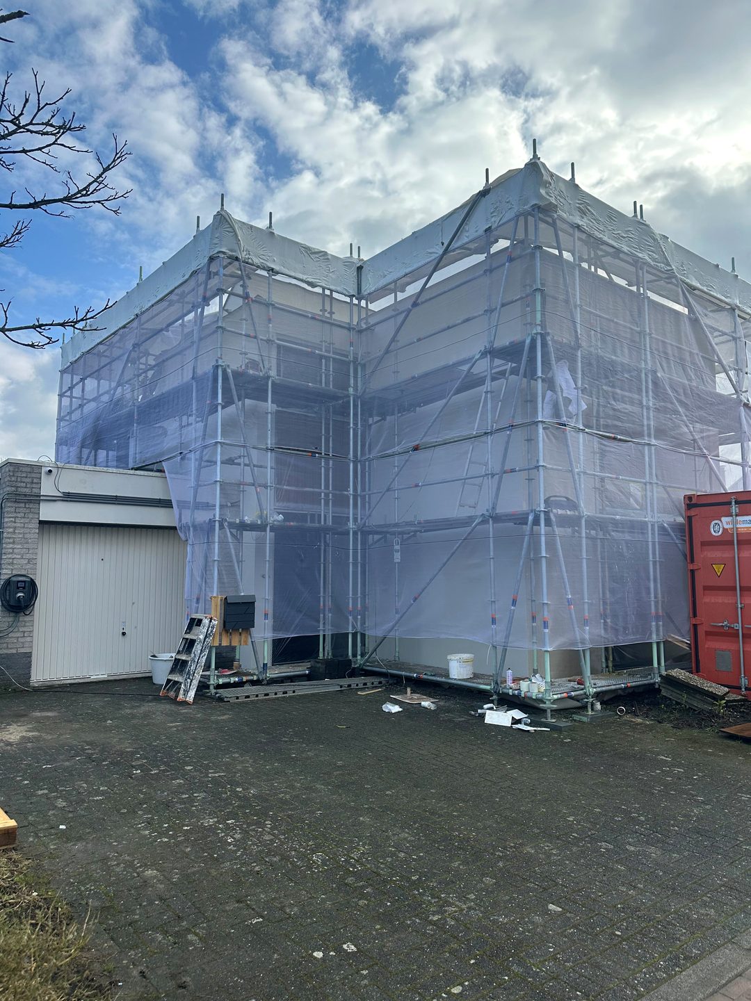Woning volledig in de steigers en ingepakt tijdens gevelwerkzaamheden