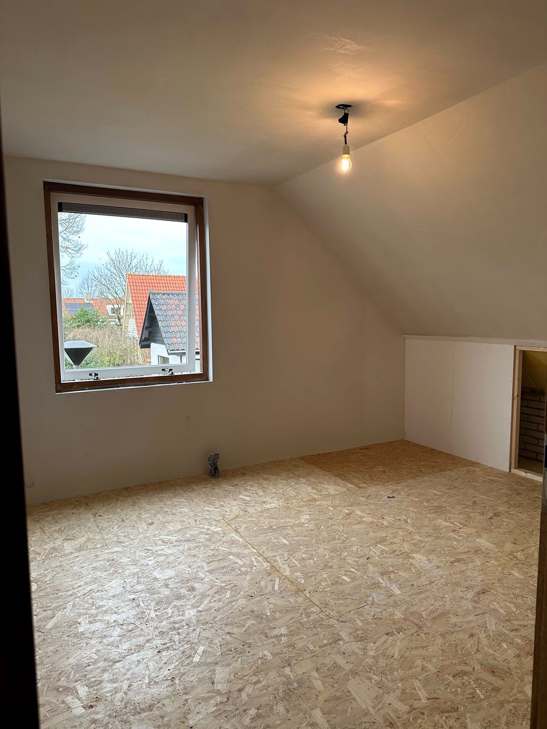Zolderkamer met gestucte wanden en schuine plafonds